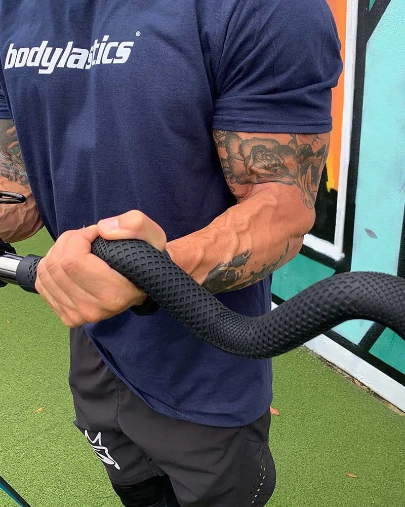 A hand wrapped around the bar's textured molded rubber grip during a curl.