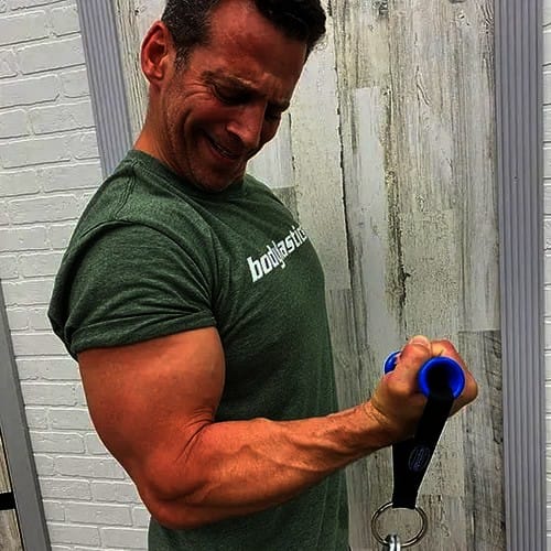 Blake today, in a Bodylastics T-shirt, curling a Bodylastics handle.